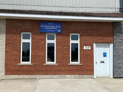 Front of library, red brick buidling, three windows and white door